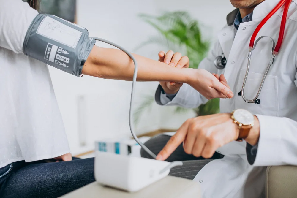 Healthcare provider checking a patient's blood pressure during a health screening
