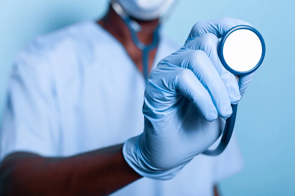 Healthcare provider holding a stethoscope during a health screening visit