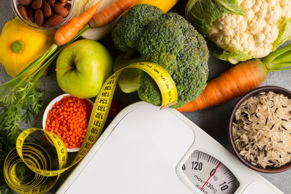 Healthy food, weighing scale, and measuring tape representing medical weight management