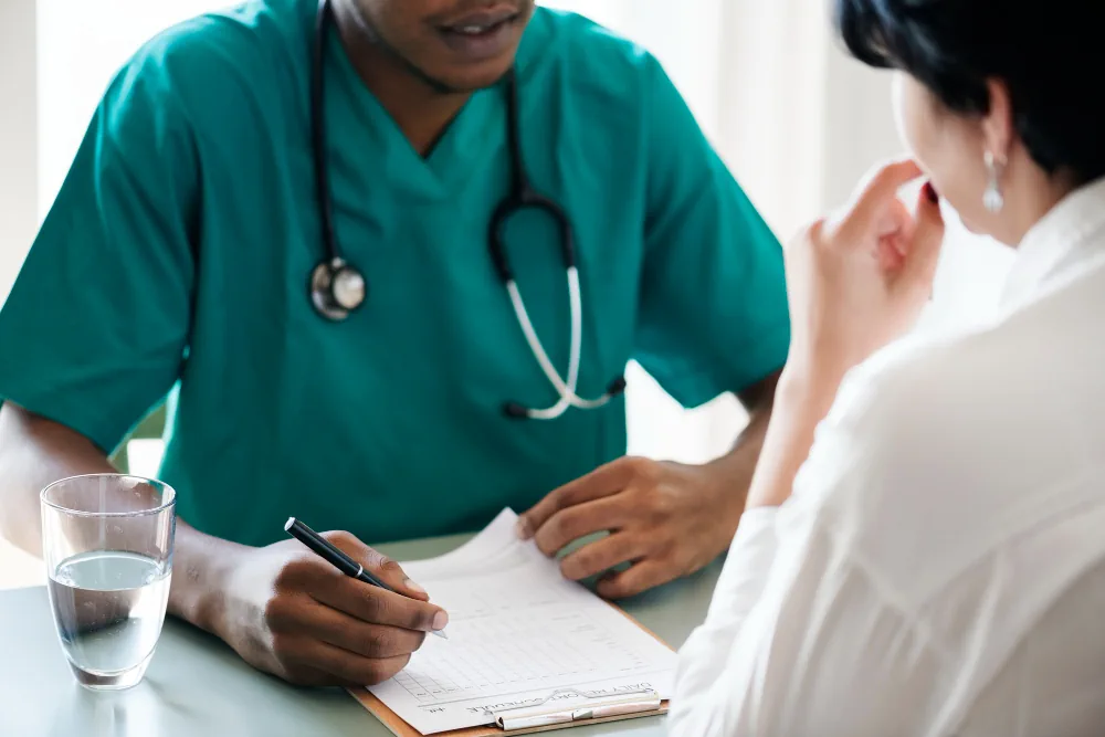 Healthcare provider taking notes during a preventive care checkup