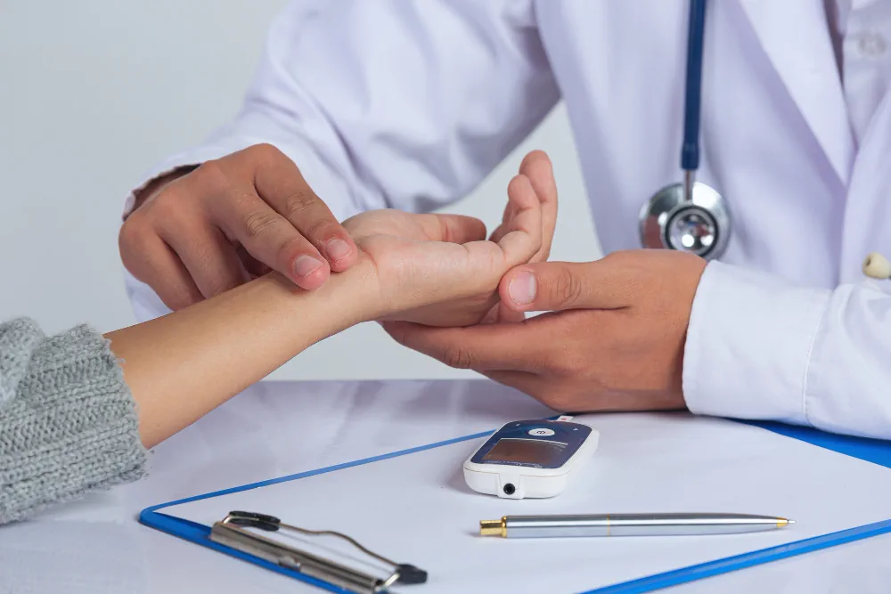 Healthcare provider examining a patient's hand during a preventive care visit