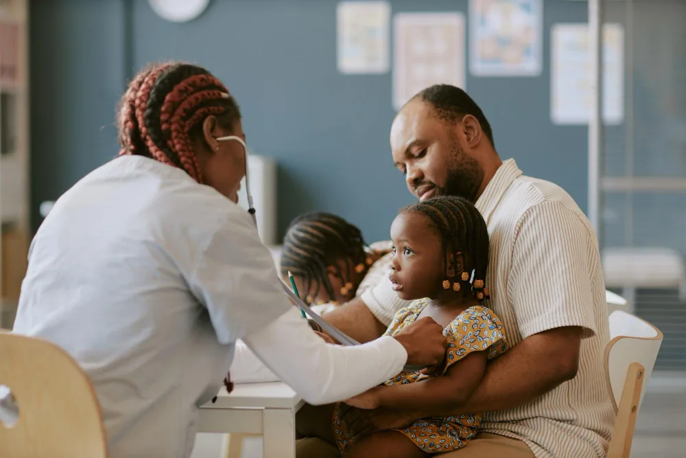Healthcare provider meeting with parents and their child during a primary care visit